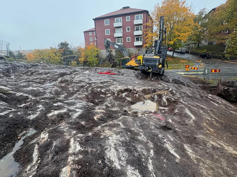 Bergarbete med borrigg intill ett bostadsområde inför bergsprängning i Stockholm